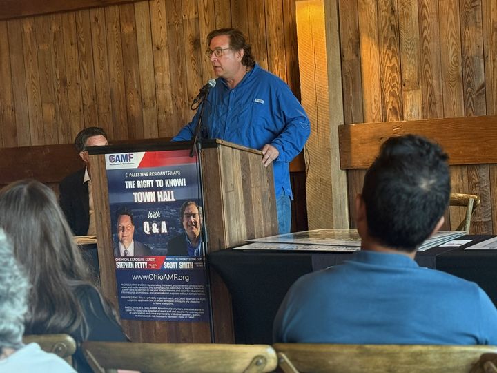 Scott Smith at the podium, the Right to Know town hall banner beside him