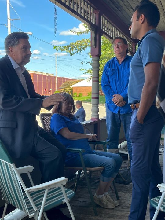 Stephen Petty talking with attendees on the porch